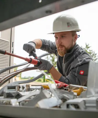 Netz NÖ Techniker mit Schutzkleidung bei der Montage an einer Trafo-Station.