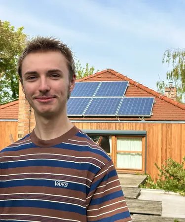 Junger Mann vor PV Anlage