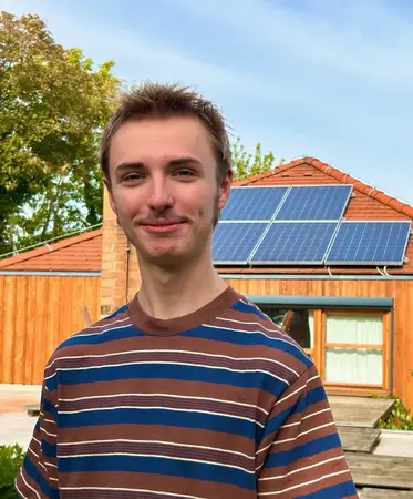 Junger Mann vor PV Anlage