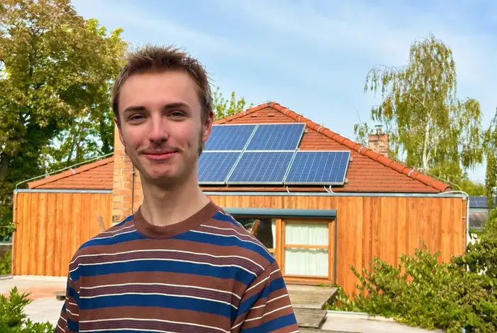 Junger Mann vor PV Anlage
