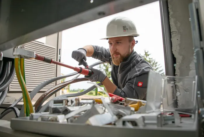 Netz NÖ Techniker mit Schutzkleidung bei der Montage an einer Trafo-Station.