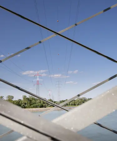 Stromleitung über die Donau durch die Metallgitter eines Masten fotografiert.
