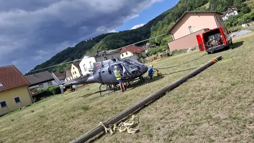 Helikopter noch am Boden. Holzmast liegt am Boden im Vordergrund.