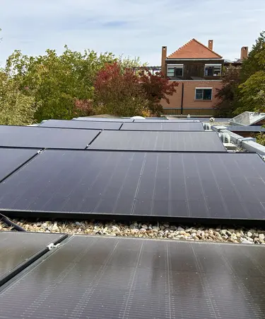 PV am Bürodach mit herbstlich gefärbten Bäumen im Hintergrund