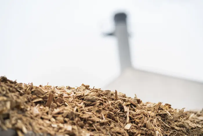 Wärmeheizwerk Guntramsdorf im Hintergrund, davor Hackschnitzel.