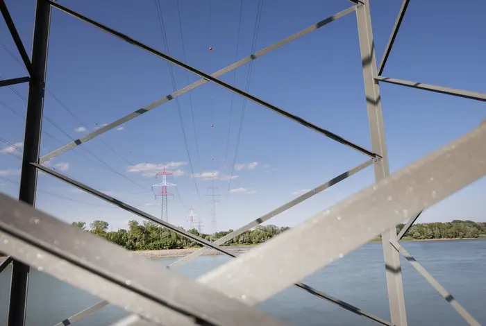 Stromleitung über die Donau durch die Metallgitter eines Masten fotografiert.