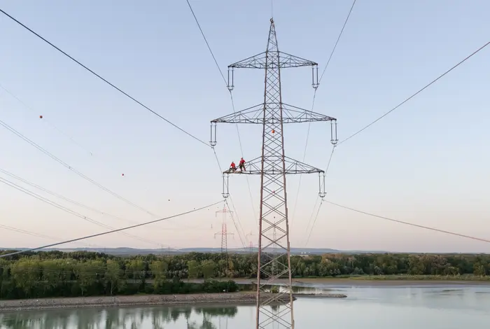 Freileitung über Donau mit 2 Mitarbeitern auf dem Leitungsmast.