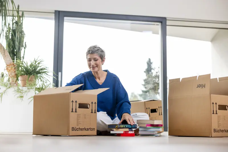 Frau packt Umzugskartons.