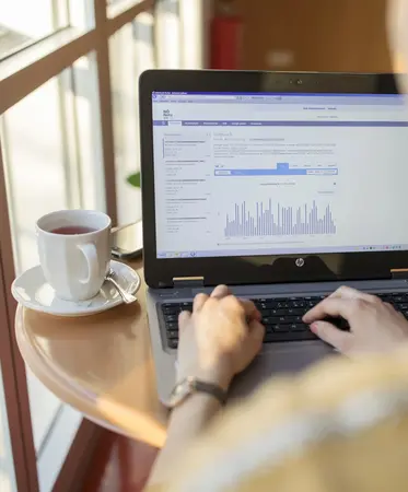 Frau schreibt sieht auf Laptop Dashboard an.