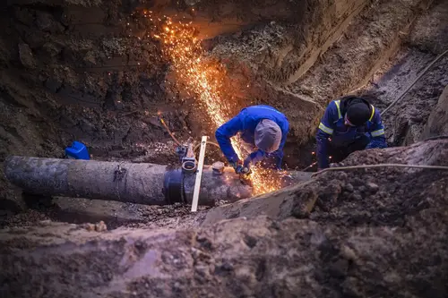 Zwei Mitarbeiter die an der Gasleitung arbeiten