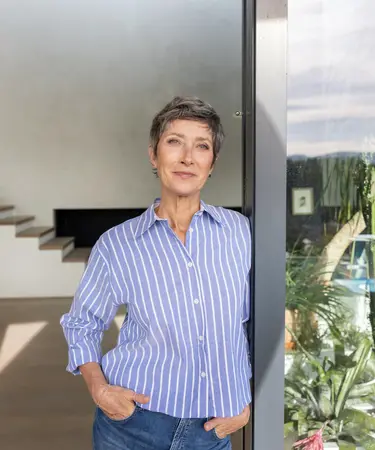 Ältere Frau stehend im Wintergarten