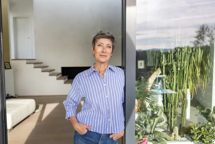 Ältere Frau stehend im Wintergarten